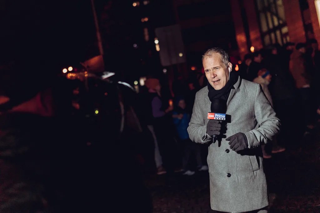 Reportér s mikrofonem CNN Prima NEWS při večerní akci ve Zlíně.