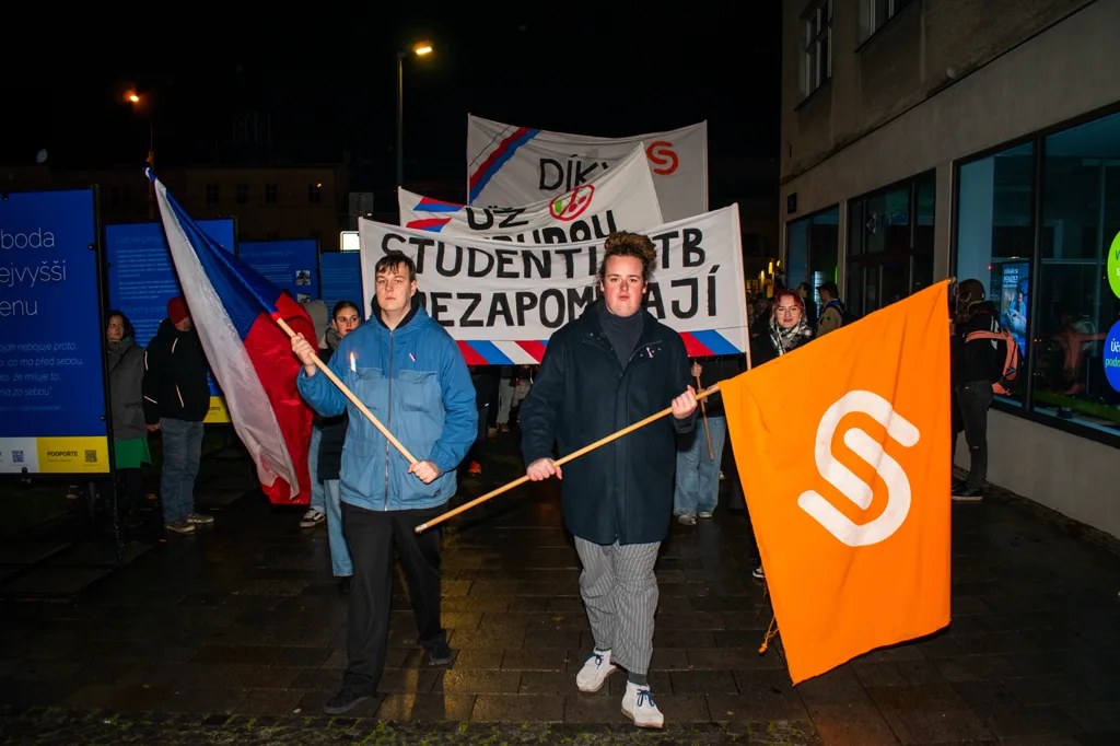 Studenti v čele průvodu nesou českou vlajku a vlajku Studentské unie.